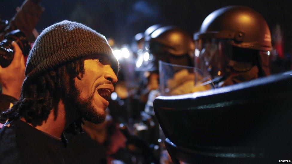 A protester confronts a police officer after the grand jury returned no indictment in the shooting of Michael Brown in Ferguson (24 November 2014)