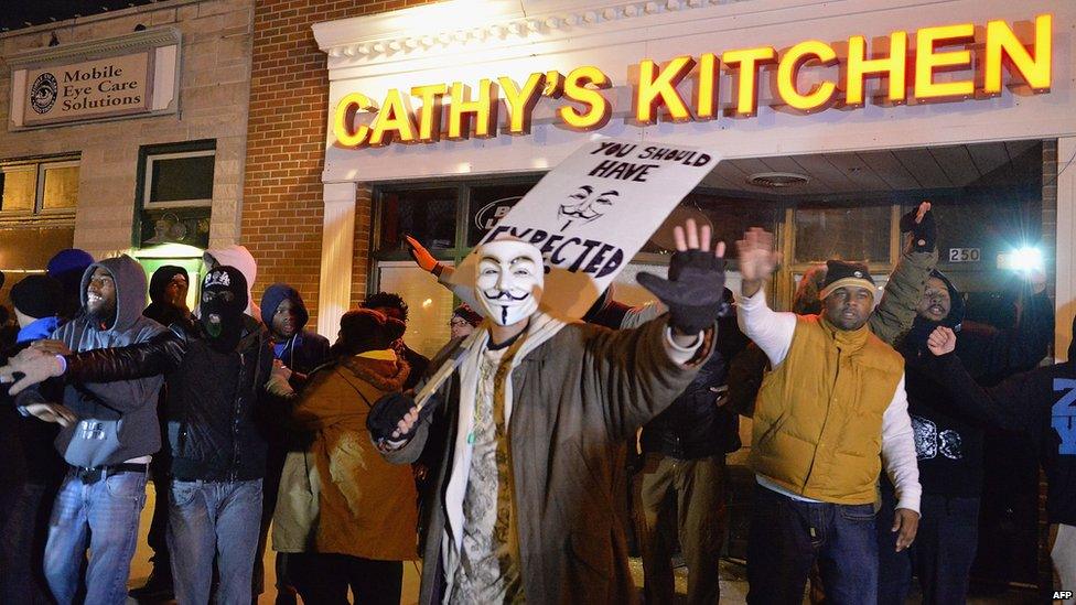 Protestors in Ferguson try to protect a business from being looted