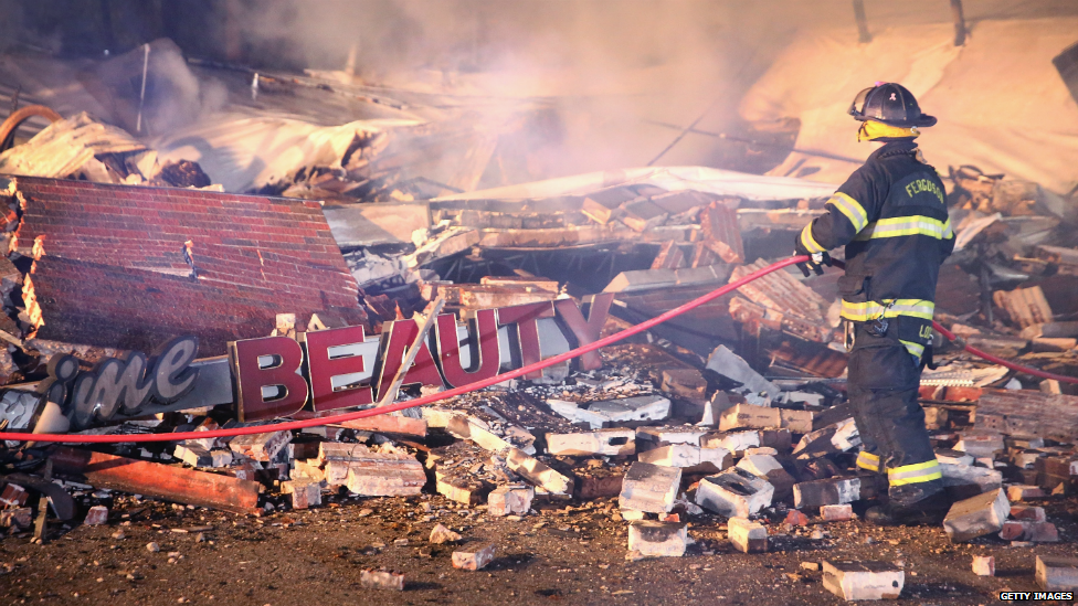 A firefighter surveys rubble at a mall that was set on fire during in Ferguson, Missouri - 25 November 2014