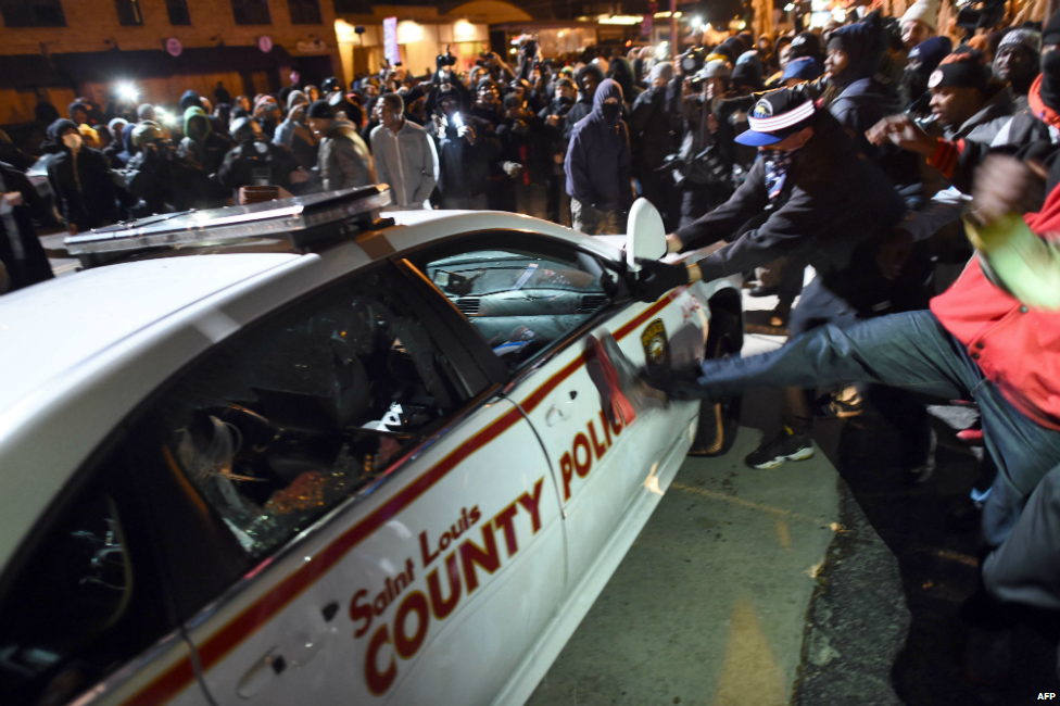 Protesters attack a police car during clashes following the Michael Brown decision in Ferguson - 24 November 2014