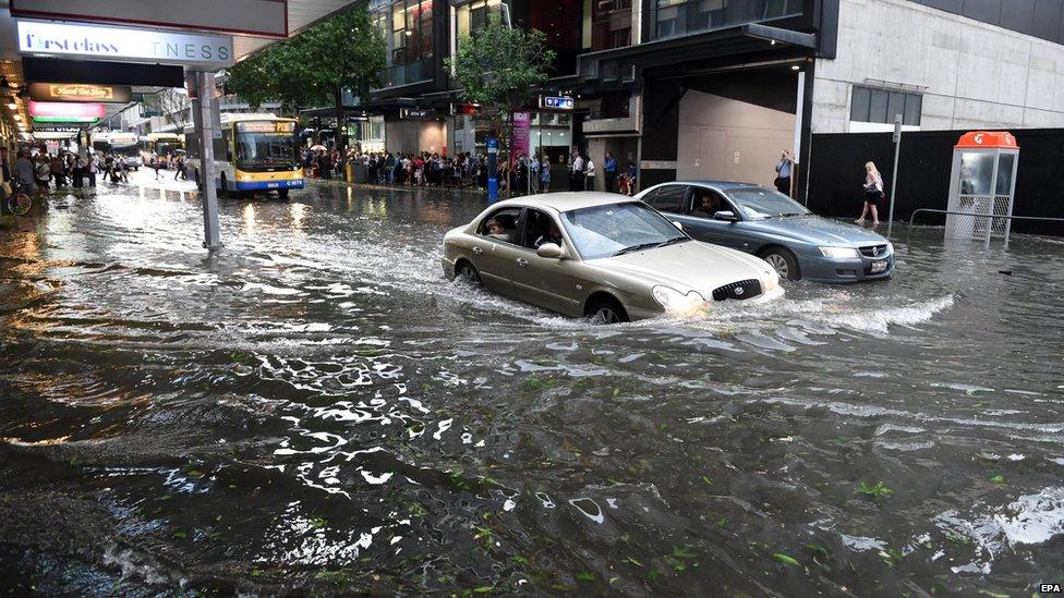 Cars drive through floodwater