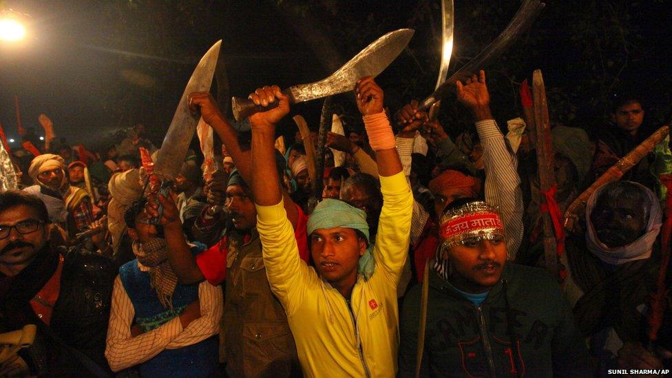 Hindu devotees brandish machetes at a festival in Nepal