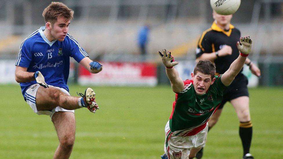 Donagh McAleenan of Warrenpoint gets his kick away despite the attempted intervention of diving Inniskeen opponent Colm Meegan