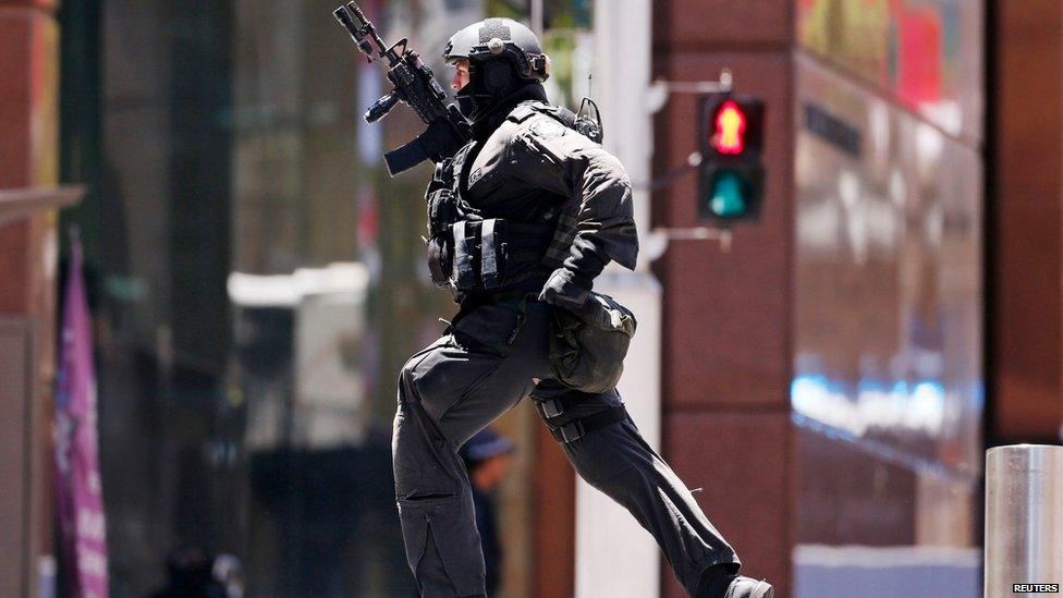 A police officer runs across Martin Place near Lindt cafe, where hostages are being held, in central Sydney December 15, 2014.