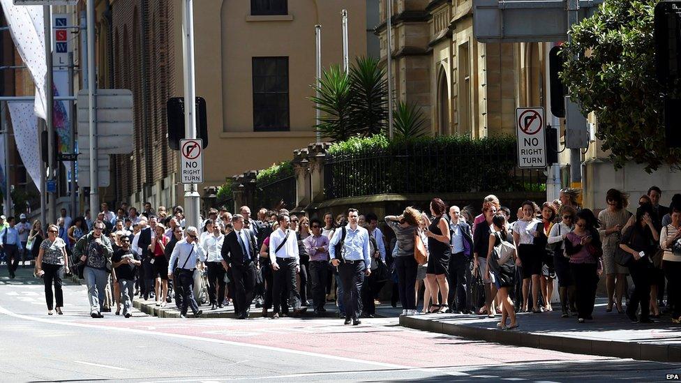 Office workers are evacuated from their buildings as a siege is underway at a Lindt cafe in Martin Place in the central business district of Sydney, Australia