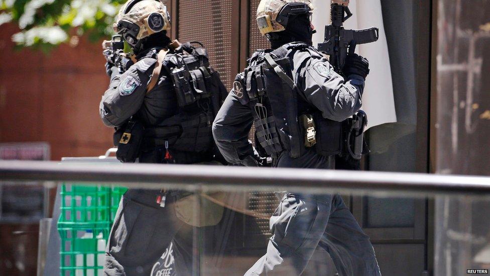 A police officer runs across Martin Place near Lindt cafe, where hostages are being held, in central Sydney December 15, 2014.