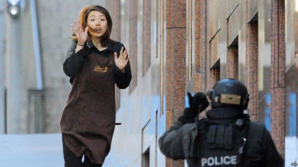 A female employee manages to escape from the Lindt Chocolate cafe in Martin Place, Sydney, Dec. 15, 2014 after a gunman took dozens of people hostage.