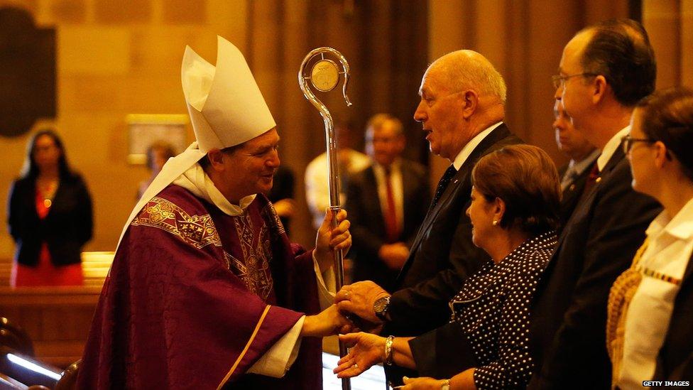 Archbishop of Sydney, Most Reverend Anthony Fisher shakes hands with Australian Governor General Peter Cosgrove during a mass to pay respect to the victims of the Martin Place siege on December 16, 2014 in Sydney.