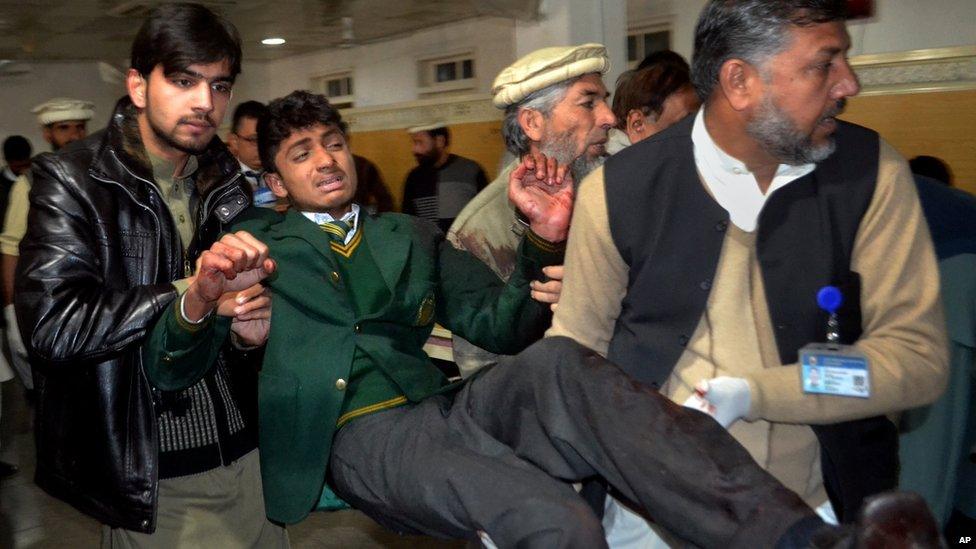 A student is helped after a gun attack at a school in Peshawar