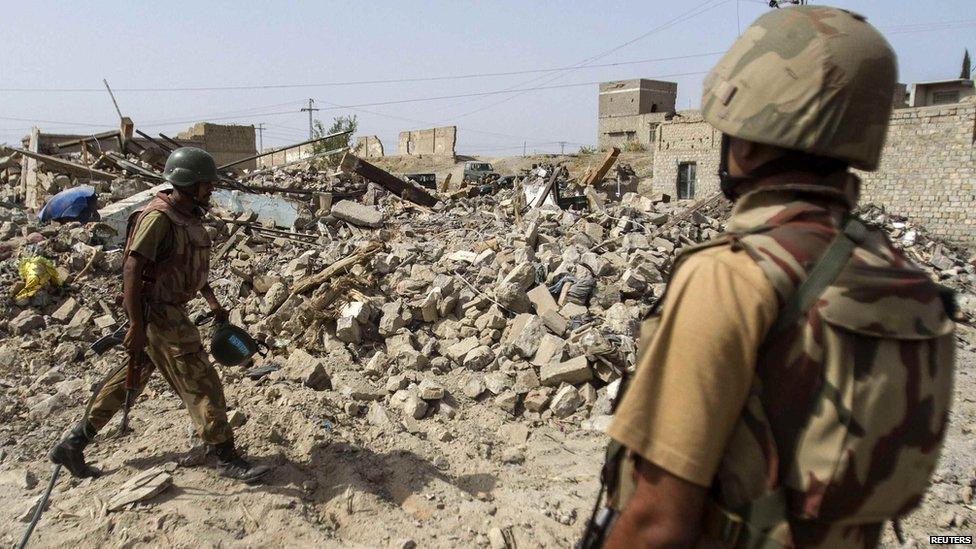 Pakistani soldiers stand near the ruins of a house in North Waziristan