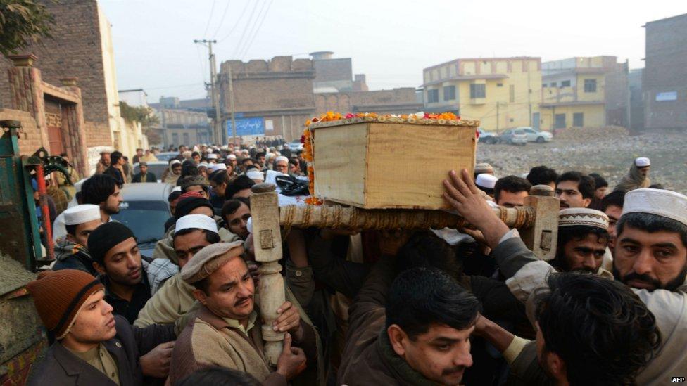 Pakistani mourners carry the coffin of a victim of an attack on an army-run school during a funeral ceremony in Peshawar - 17 December 2014