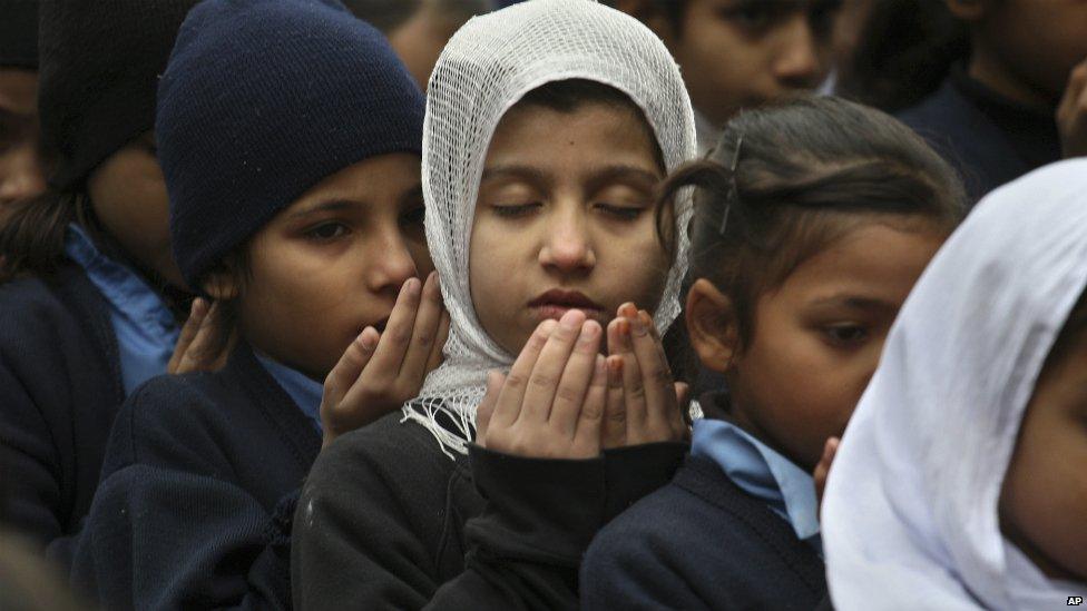 Pakistani students pray during a special ceremony for the victims of Tuesday's attack in Peshawar, at a school in Lahore - 17 December 2014