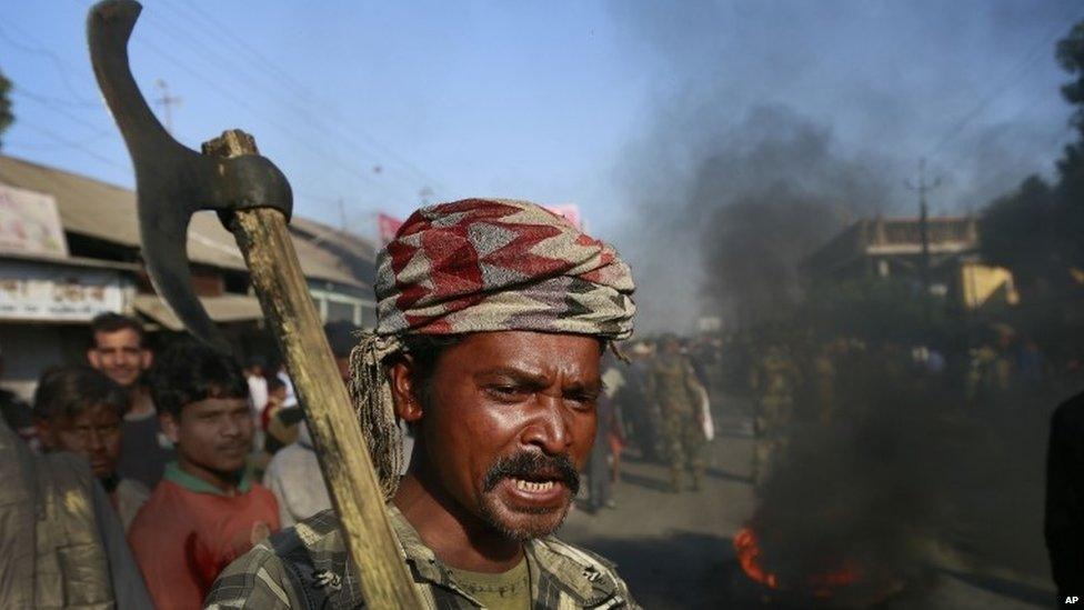 An Indian tribal settler shout slogans as he blocks a road with other in protest against the attack by an indigenous separatist group on their villages, in Shamukjuli village in Sonitpur district of Indian eastern state of Assam, Wednesday, Dec. 24, 2014.