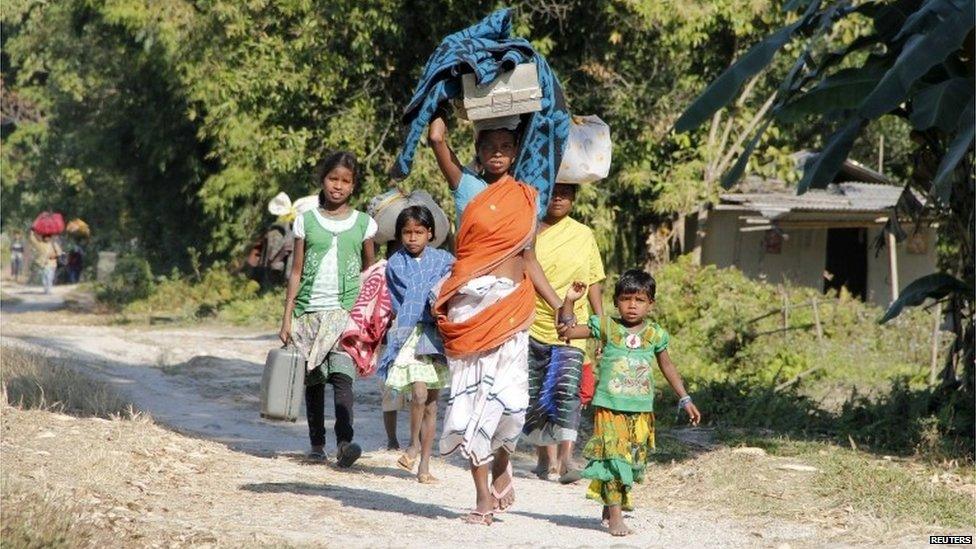 A family carries their belongings as they move to a safer place after ethnic clashes in Tenganala village, in Sonitpur district in the northeastern Indian state of Assam December 24, 2014.