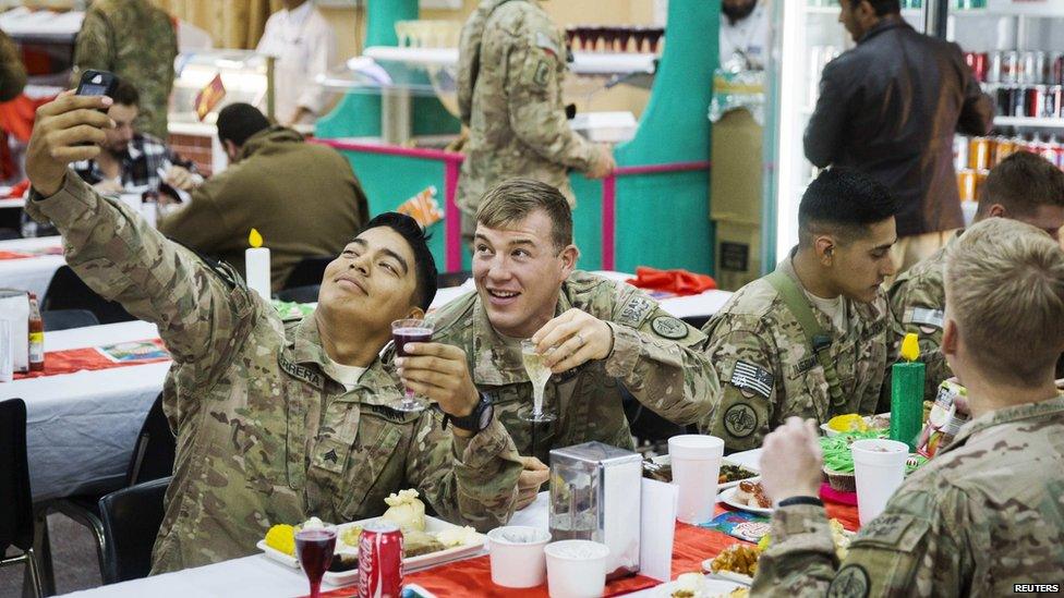 U.S. soldiers from the 3rd Cavalry Regiment pose for a photograph while eating a Christmas day lunch at forward operating base Gamberi in the Laghman province of Afghanistan December 25, 2014