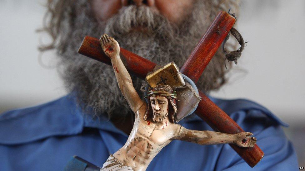 An Indian Christian holds a crucifix during Christmas prayers at St Mary's Garrison church, in Jammu, India, Thursday, Dec. 25, 2014