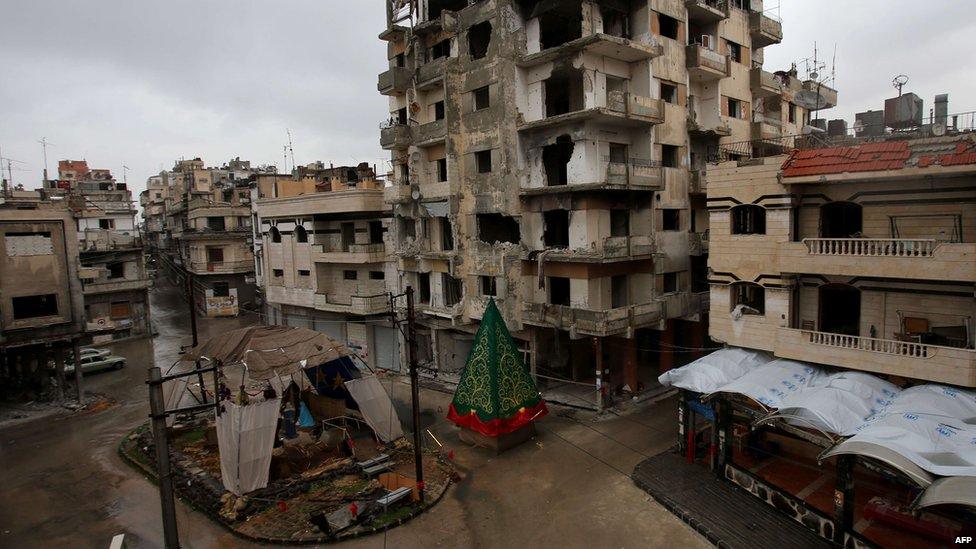 A crib made out of rubble and a Christmas tree are set on a roundabout in the regime-held Hamedieh neighbourhood in the Syrian city of Homs on December 22, 2014, as Christians around the world prepare to celebrate the holy day.