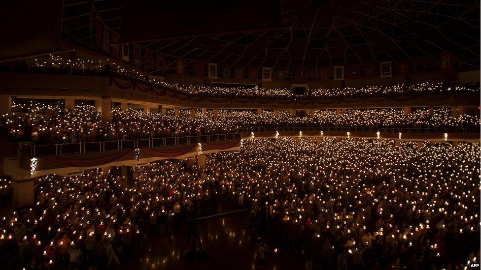 In this picture taken on December 24, 2014 Christians hold candles during the mass service in Surabaya, in the eastern Java island. Millions of Christians in Indonesia celebrated Christmas eve in the most populous Muslim country.