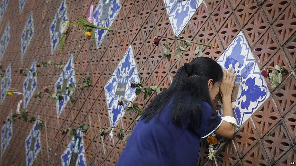 A woman offers prayers on a tiled memorial wall displaying names of the tsunami victims in Phang Nga, Thailand. Photo: 26 December 2014