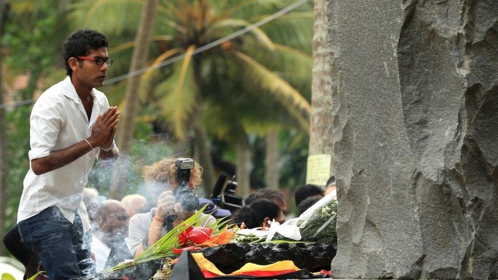 A Sri Lankan tsunami survivor prays for victims at a special memorial monument in Peraliya. Photo: 26 December 2014