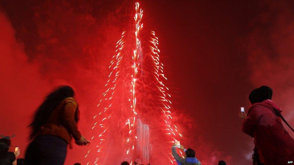 People watch as Dubai celebrates the new year with a light and sound extravaganza at midnight at the Burj Khalifa, the world"s tallest tower (31 December 2014)
