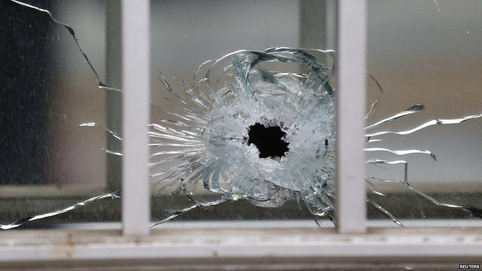 A bullet's impact is seen on a window at the scene after a shooting at the Paris offices of Charlie Hebdo, a satirical newspaper on 7 January , 2015.