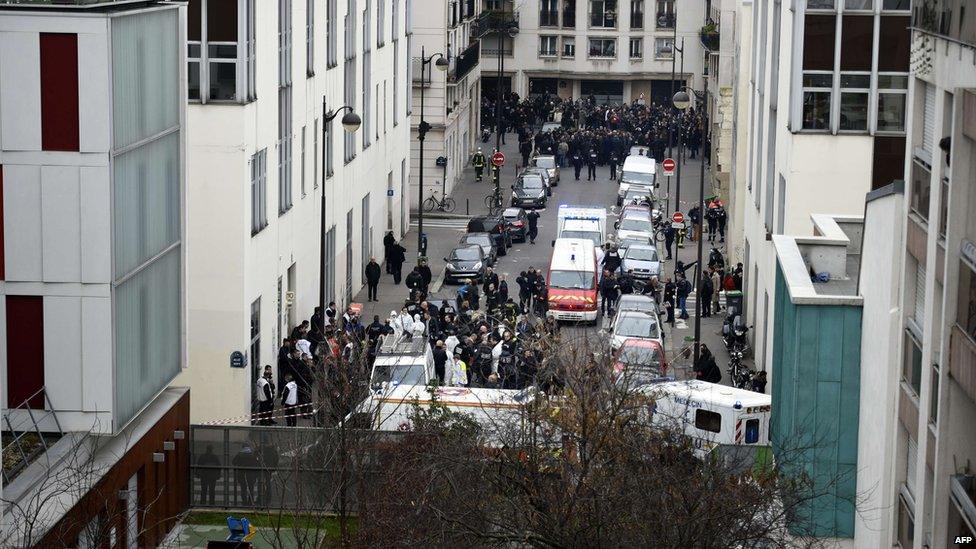 A general view shows firefighters, police officers and forensics gathered in front of the offices of the French satirical newspaper Charlie Hebdo in Paris