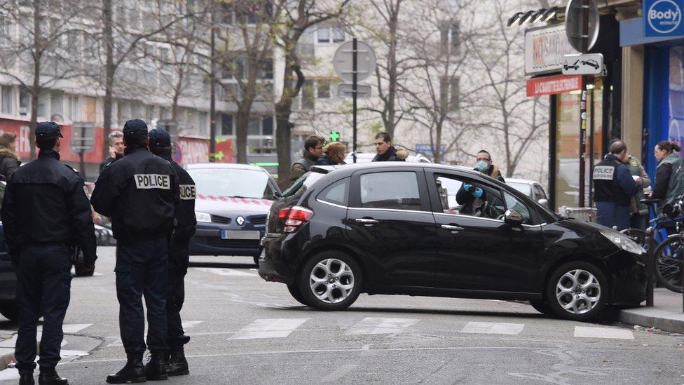 French police officers stand next to the car used by armed gunmen who stormed the Paris offices of satirical newspaper Charlie Hebdo on 7 January 2015