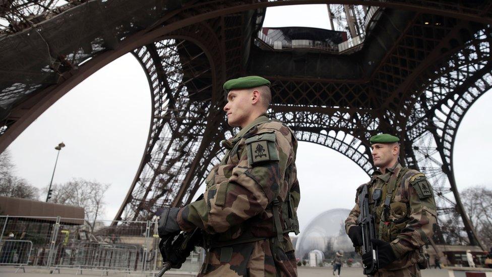 French soldiers patrol in front of the Eiffel Tower on January 7, 2015 in Paris as the capital was placed under the highest alert status