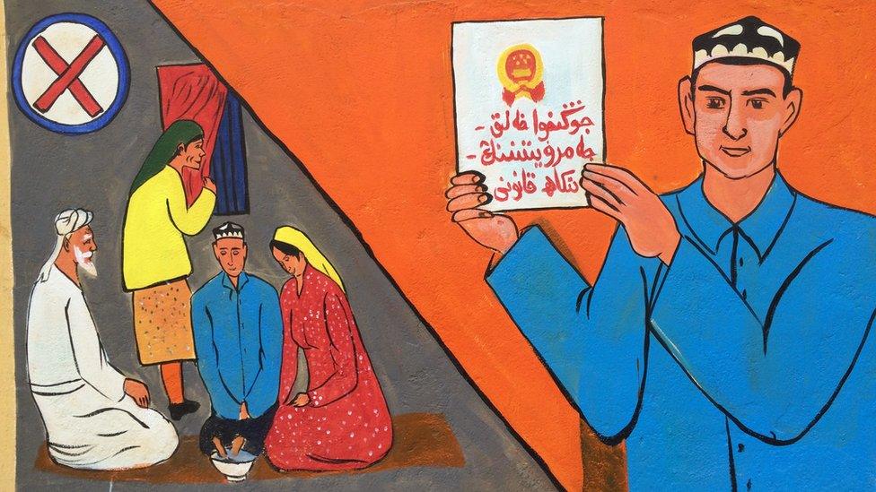 A mural is painted on the walls next to a mosque in the old Silk Road district of Kashgar