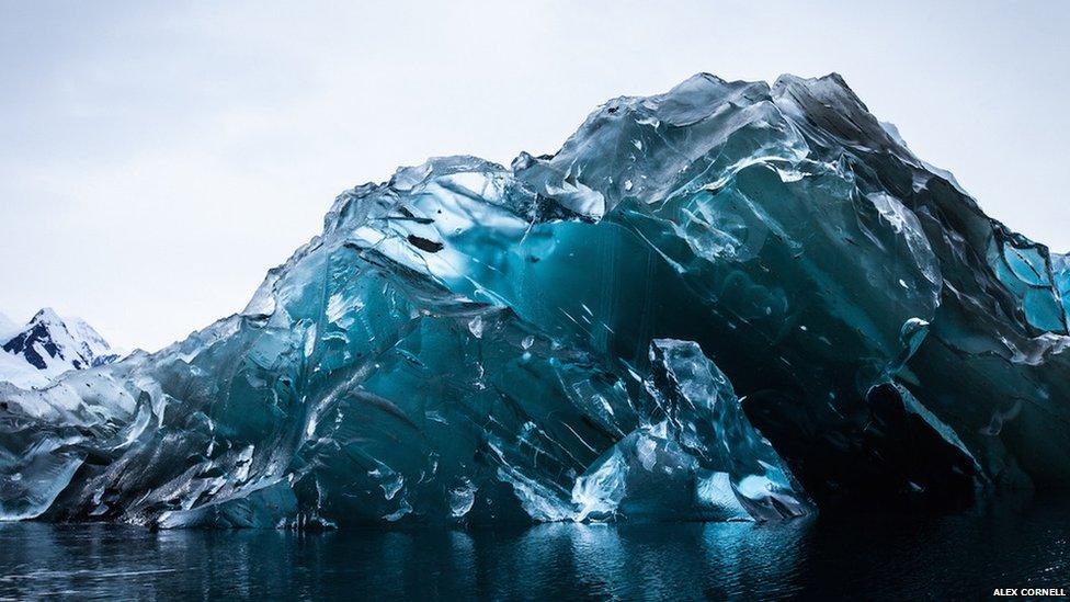 a photograph of an upside down iceberg.