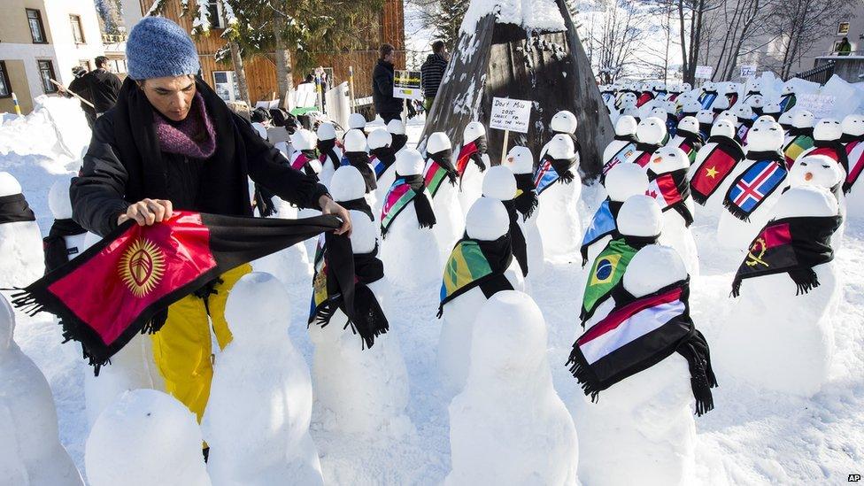 A member from Action 2015 puts a scarf on one of the snowmen representing the countries around the world