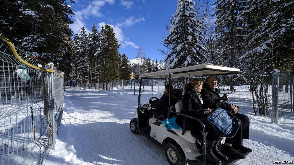 Davos attendees in golf cart