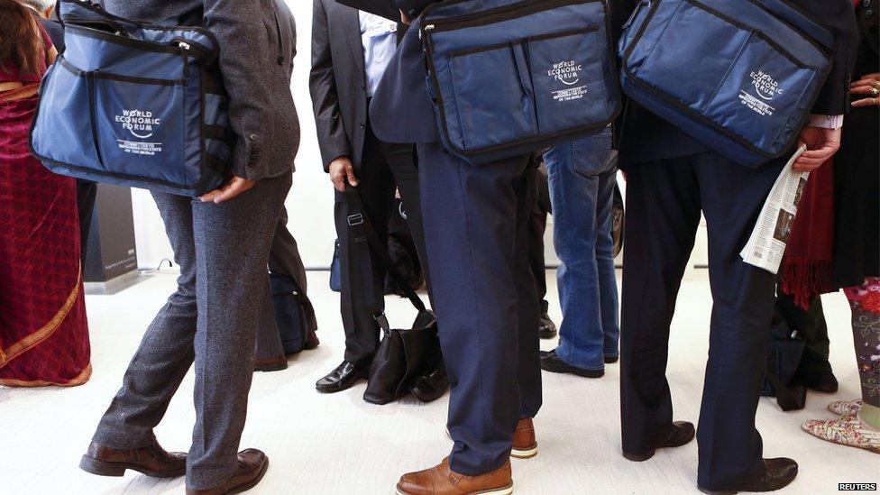 Members stand in a queue to enter a session of the World Economic Forum in the Swiss mountain resort of Davos