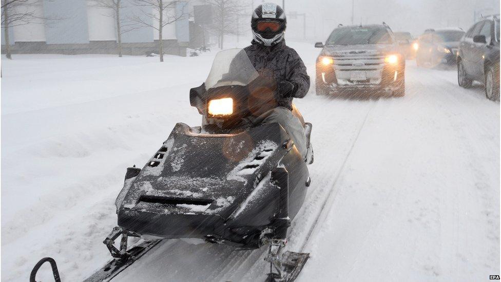 A man driving a snowmobile.