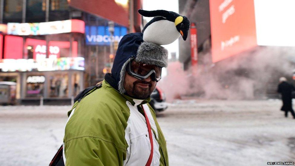 A man wearing a hat with a penguin on it walks at the nearly deserted New York's Times Square