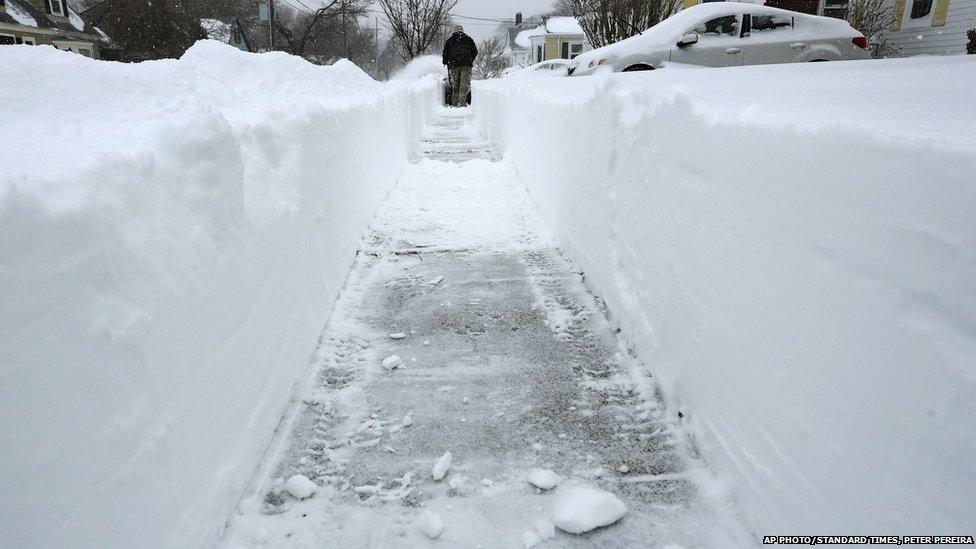 Charlie Glover leaves a two foot tall path as he uses a snow blower to dig himself out of the snow on Tuesday, Jan. 27, 2015 in New Bedford, Mass