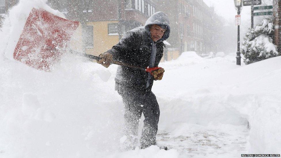 Henry Reyes shovels the sidewalk on Mt. Vernon Street during a blizzard in Boston, Massachusetts January 27, 2015