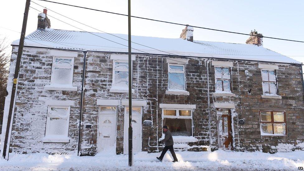 A man walks through Tow Law, County Durham after heavy snow hit the region on Wednesday night