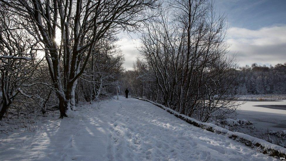 People take a walk in snow covered Drumpellier Park, Coatbridge