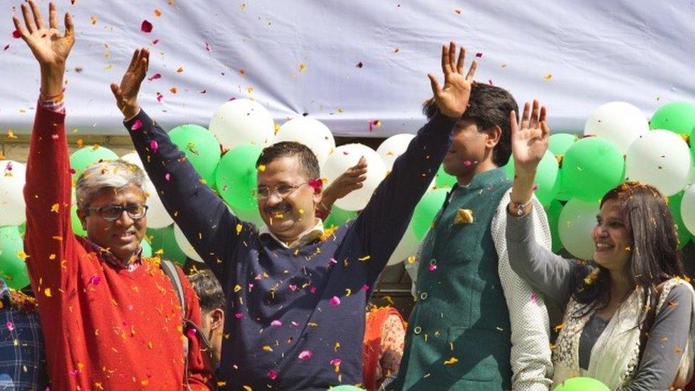 Aam Aadmi Party leaders Arvind Kejriwal, center, waves to the crowd as his party looks set for a landslide party in New Delhi, India, Tuesday, Feb. 10, 2015