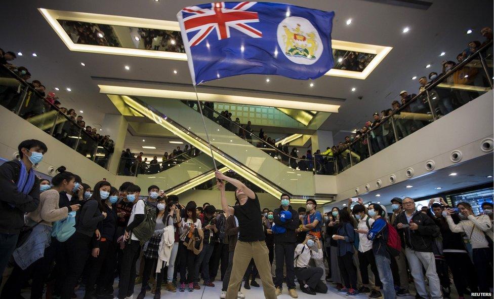 Protester waves colonial-era flag in Hong Kong shopping centre (15 Feb 2015)