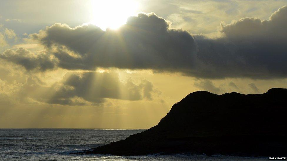 This image of sunlight shining through clouds before sunset at Tears Point, on Gower, Swansea, was taken by Mark Baker.