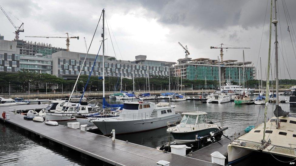 This photograph taken on 14 November 2013 shows a view of the yacht club with new buildings on the rise at the background in the southern state of Johor Bahru bordering Singapore. Construction cranes are sprouting across southern Malaysia's Johor state as investment flows into 'Iskandar', a development zone that aims to draw Singaporean capital to its larger neighbour's cheaper land and labour costs.