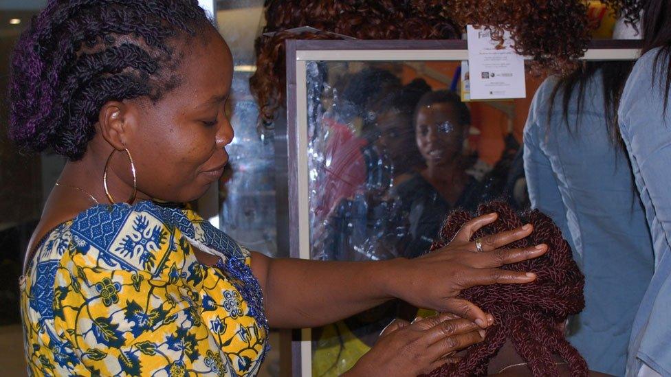 A hairdresser fixing braids at Bruno's Place hair salon in Ikeja Mall in Lagos, Nigeria