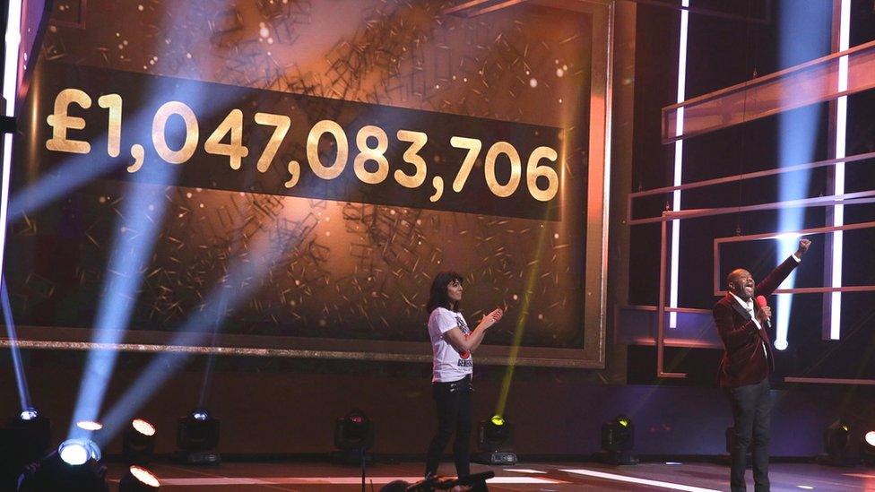 Video screen displaying Comic Relief fundraising total of 1,047,083,706 pounds.
