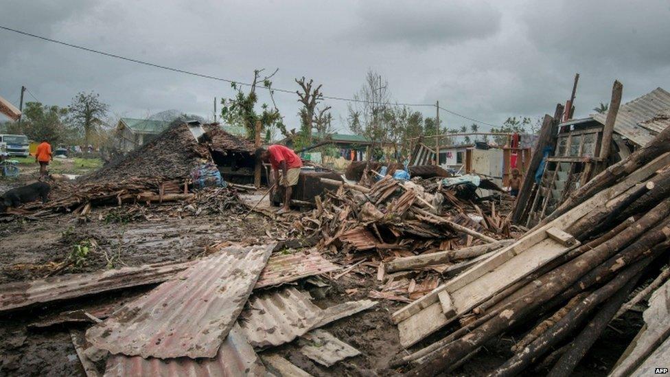 Local residents move debris near their homes destroyed by Cyclone Pam in Port Vila, the capital city of the Pacific island nation of Vanuatu 15 March 2015