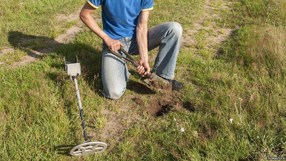 Metal detectorist digging