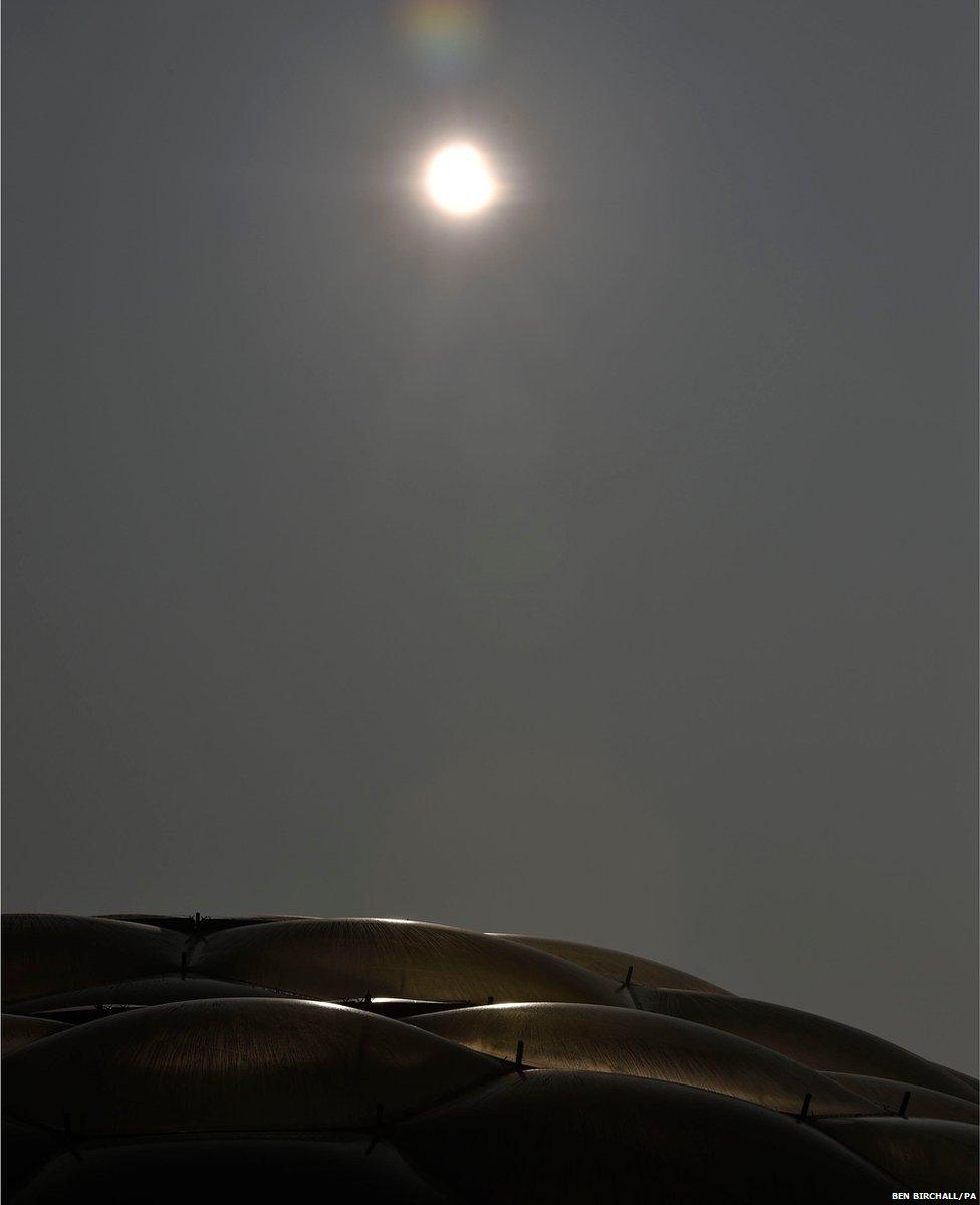 An eclipse of the sun begins over the Eden Project near St Austell in Cornwall, England