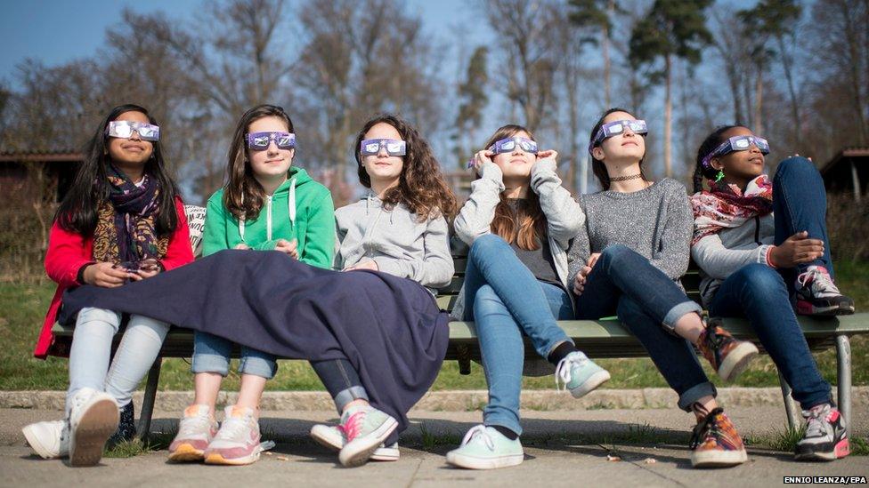 Teenagers wearing solar glasses